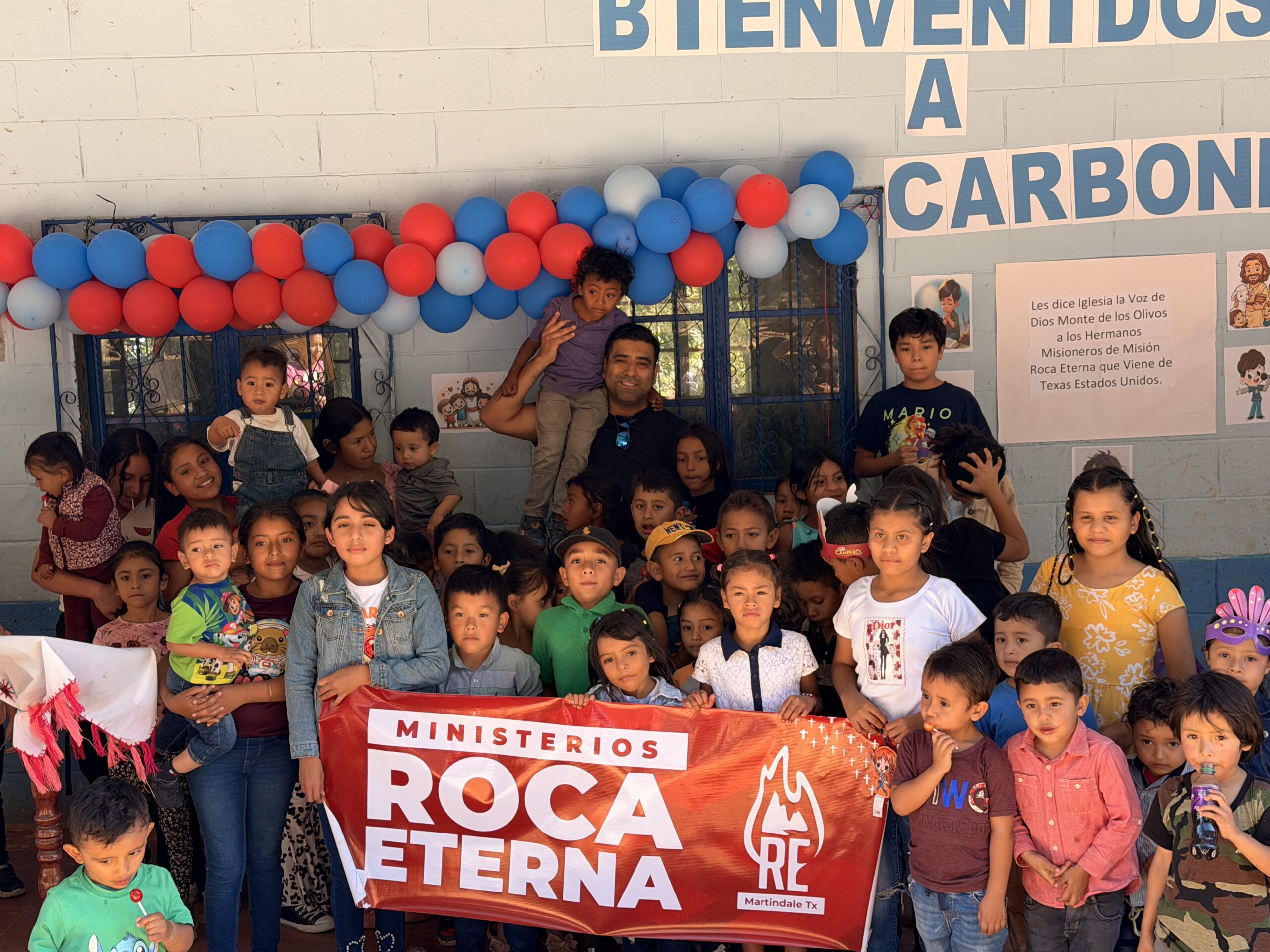 Niños y familias junto al equipo de Ministerios Roca Eterna durante una visita misionera